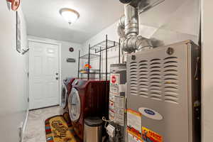 Clothes washing area featuring gas water heater, independent washer and dryer, and heating unit