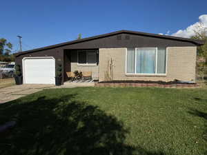 View of front of house featuring a front yard and a garage