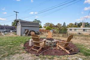 View of yard with a storage unit and a fire pit