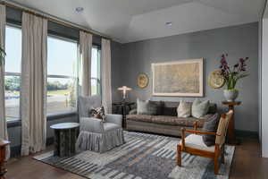 Living room featuring wood-type flooring and vaulted ceiling