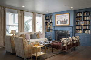 Living room featuring a high end fireplace, a textured ceiling, and dark hardwood / wood-style floors