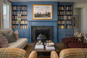 Living area with a textured ceiling, a fireplace, and built in shelves