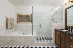 Bathroom with vanity, shower with separate bathtub, and tile patterned floors