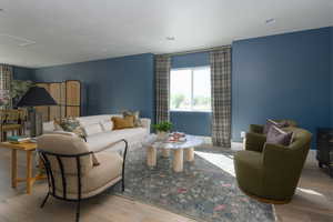 Living room with a textured ceiling and light hardwood / wood-style flooring