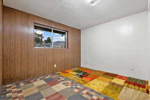 Unfurnished bedroom with wooden walls