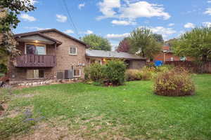 View of yard featuring central air condition unit and a balcony