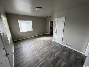 Unfurnished bedroom featuring dark wood-type flooring