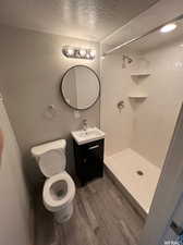 Bathroom with toilet, walk in shower, and hardwood / wood-style flooring