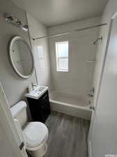 Full bathroom featuring vanity, toilet, bathtub / shower combination, and wood-type flooring