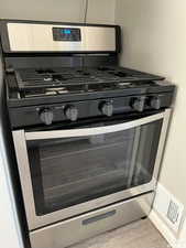 Interior details featuring stainless steel range with gas cooktop and light hardwood / wood-style flooring