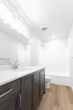 Full bathroom featuring bathtub / shower combination, vanity, hardwood / wood-style flooring, and toilet