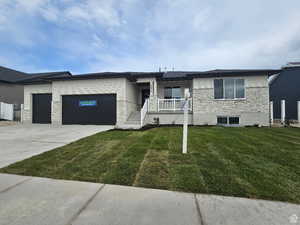 View of front facade with a front yard and a garage