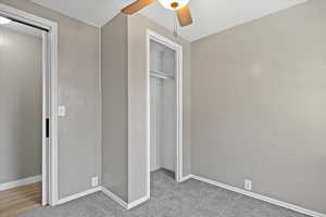 Unfurnished bedroom featuring carpet floors, a closet, and ceiling fan