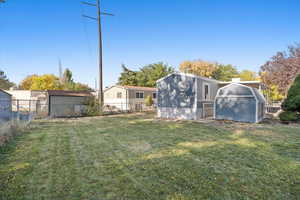 Rear view of house with a yard and a storage shed