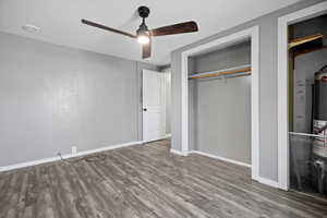 Unfurnished bedroom with hardwood / wood-style floors, a closet, and ceiling fan