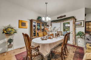 Dining area with a notable chandelier and wood-type flooring