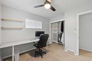 Office area with carpet floors and ceiling fan