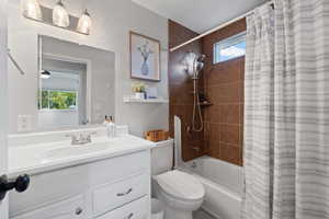 Full bathroom featuring vanity, toilet, and shower / tub combo with curtain