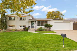 Split level home featuring a front yard and a garage