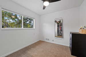 Unfurnished bedroom featuring ceiling fan and carpet flooring