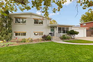 Tri-level home with a garage and a front lawn