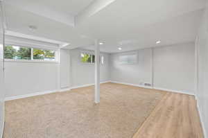 Basement with light hardwood / wood-style flooring