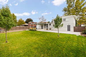 Rear view of house featuring a yard and a carport