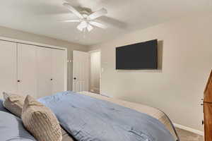 Bedroom featuring a closet, ceiling fan, and carpet flooring