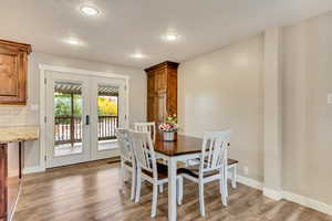 Dining space with french doors, hardwood / wood-style floors, and a textured ceiling