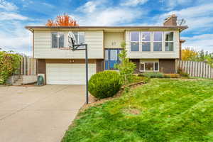 Split foyer home with a front yard and a garage