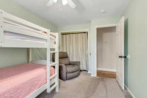 Bedroom with a closet, ceiling fan, and carpet