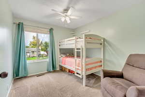 Carpeted bedroom featuring ceiling fan