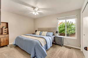 Bedroom with light carpet, a closet, and ceiling fan