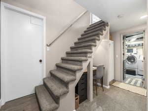 Staircase with independent washer and dryer and hardwood / wood-style floors