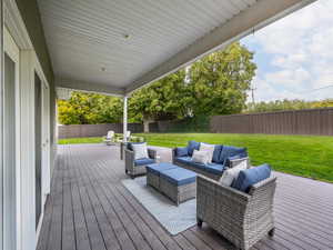 Wooden deck featuring a lawn and an outdoor hangout area