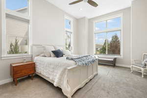 Carpeted bedroom featuring ceiling fan