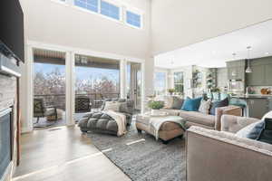 Living room with light hardwood / wood-style flooring and a high ceiling