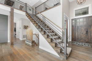 Entrance foyer featuring a towering ceiling, a notable chandelier, and hardwood / wood-style flooring