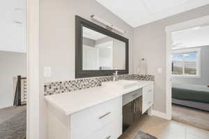 Bathroom with vanity, decorative backsplash, and tile patterned flooring