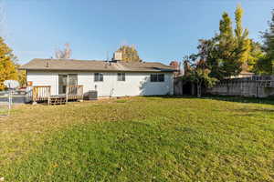 Back of property featuring a wooden deck, a yard, and central AC unit