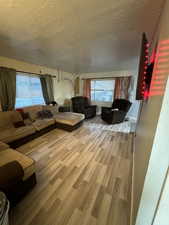 Unfurnished living room with light hardwood / wood-style floors and a textured ceiling