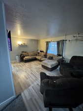 Living room with a textured ceiling and wood-type flooring