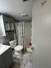 Bathroom with toilet, tile walls, vanity, and a shower with shower curtain