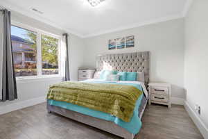 basement bedroom #6 with ornamental molding and wood-type flooring