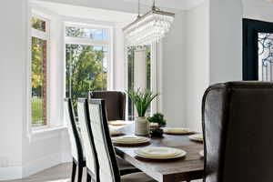 Dining space with light hardwood / wood-style flooring, crown molding, a notable chandelier, and plenty of natural light