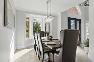 Dining space featuring a chandelier, crown molding, and light hardwood / wood-style floors