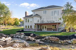 Rear view of property with french doors, a patio area, and a lawn