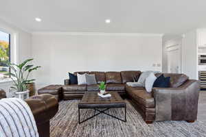 Living room with ornamental molding and hardwood / wood-style flooring