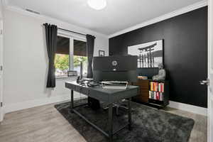 basement office area with crown molding and wood-type flooring