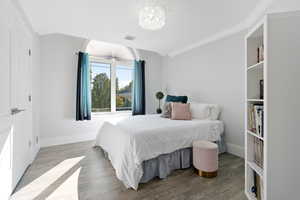 upstairs bedroom #3 with crown molding, a notable chandelier, and light wood-type flooring